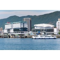 向島から見た渡船と尾道駅周辺の街並み